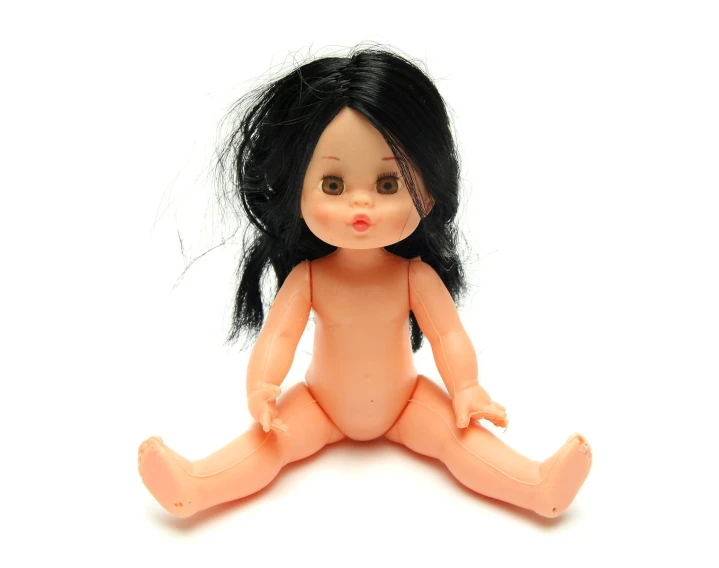 a small,  doll is sitting on a white surface