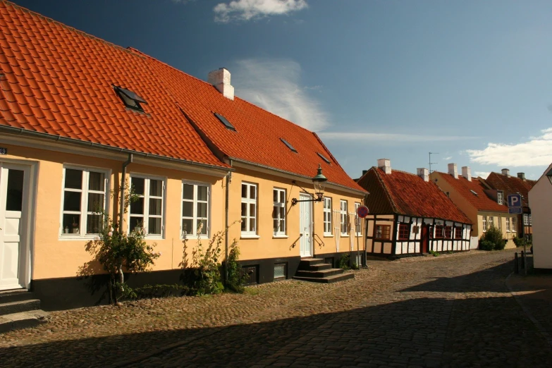 a street lined with houses that have orange tiled roofs