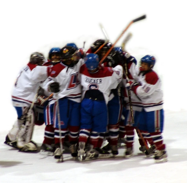 a group of s standing in a huddle while playing hockey