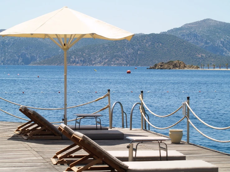 two chairs on the pier in front of the water