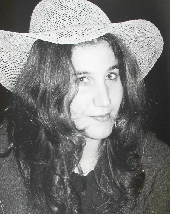 a woman wearing a hat with hair flowing down the side