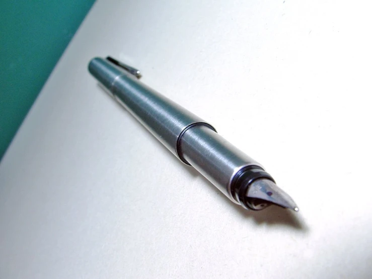 a close up of a pen on top of a white surface