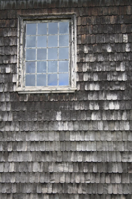 a window sitting on the side of a wooden building