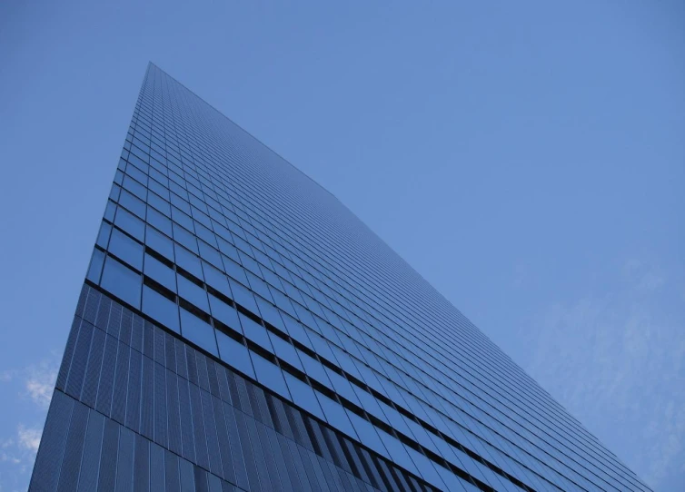 blue glass building in the sun with its reflection on it