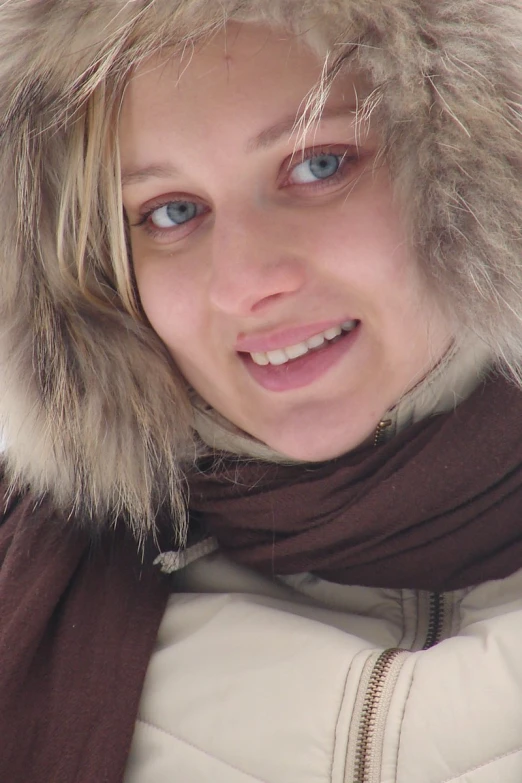 a woman is smiling wearing a fur coat