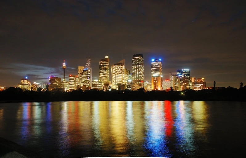 the skyline is reflected in the water at night