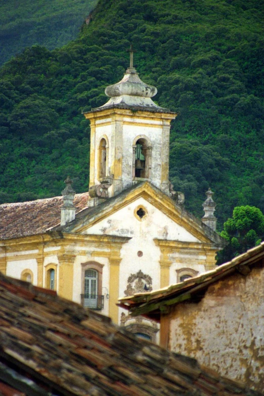 old house and steeple with mountains in the background