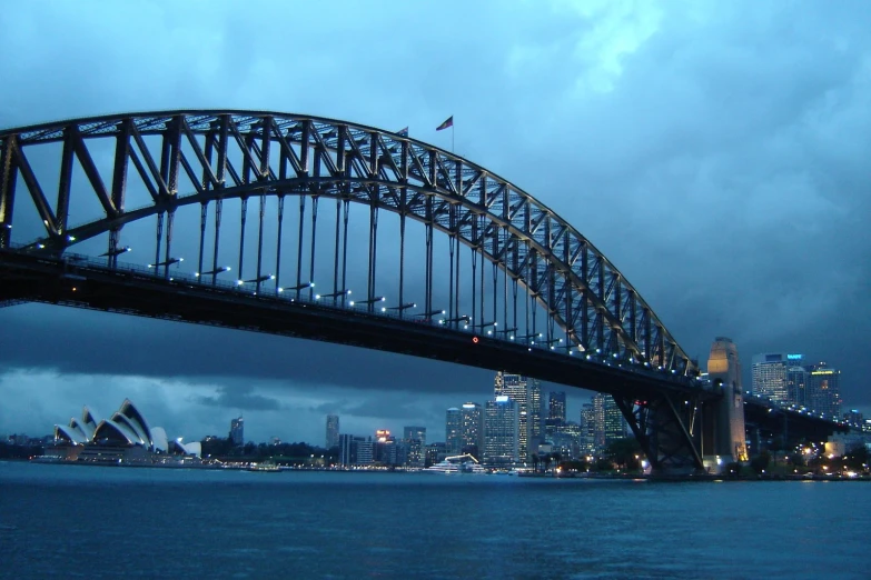 the bridge has a metal arch and is lighted up by lights