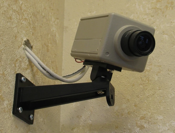 a camera attached to a wall mounted shelf with a couple of keys