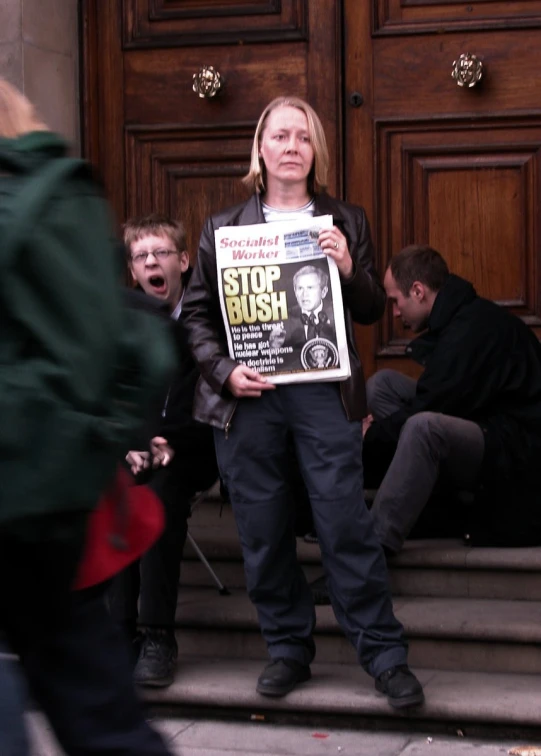 a woman standing holding up a poster