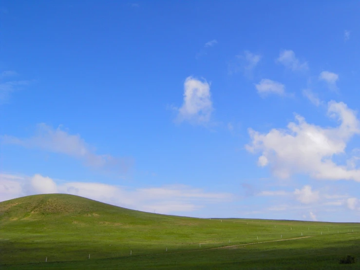 a hill with a grassy hill side in the distance