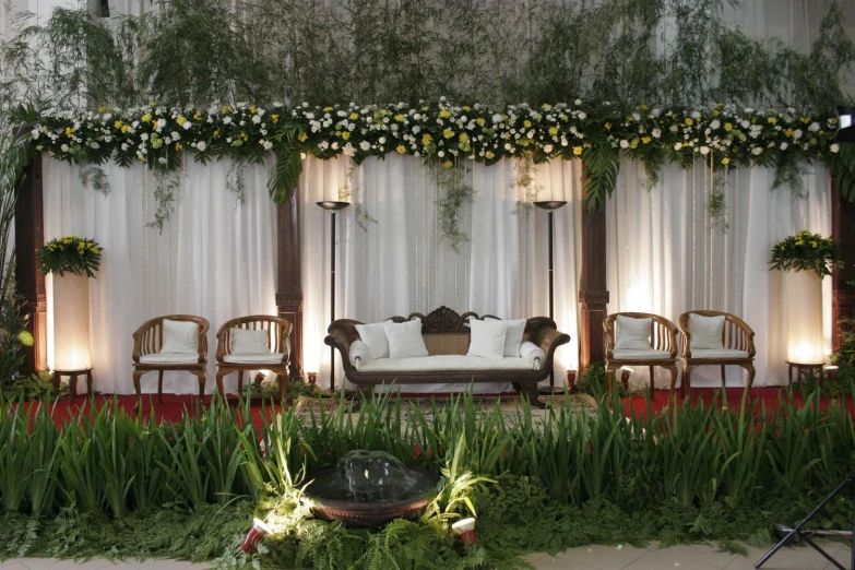 a couch sitting under a large window next to a lush green forest