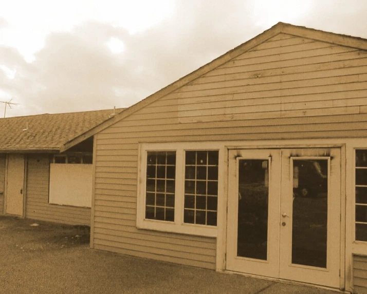 an empty old style house sits outside on a cloudy day