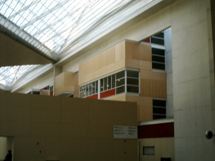 a glass ceiling in a building that contains a building with red and white columns