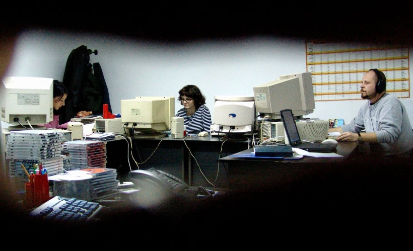 two people work on laptops at a computer desk