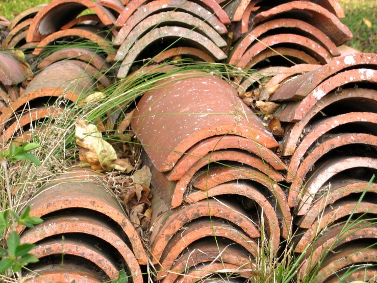 large red metal pipes stacked on top of each other in grass