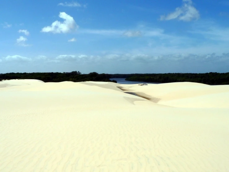 some very thin sand near the water under some clouds