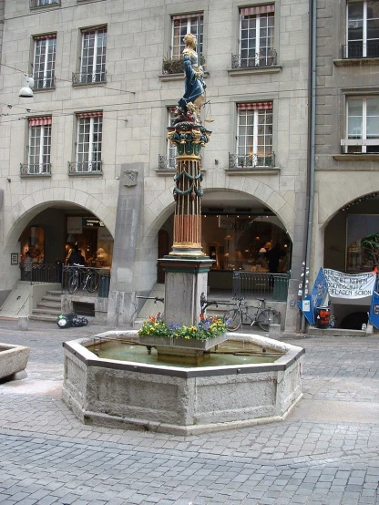 the fountain in front of a building in the center of the city