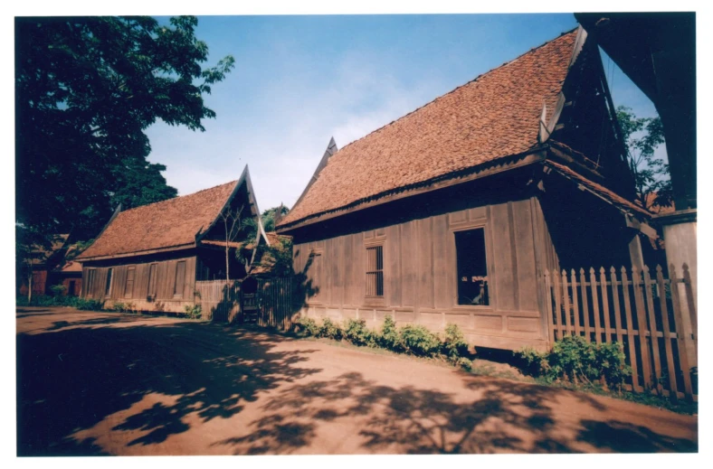 a large wooden building sitting next to a lush green field