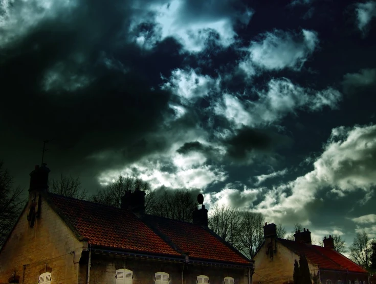 the building has windows open and many dark clouds