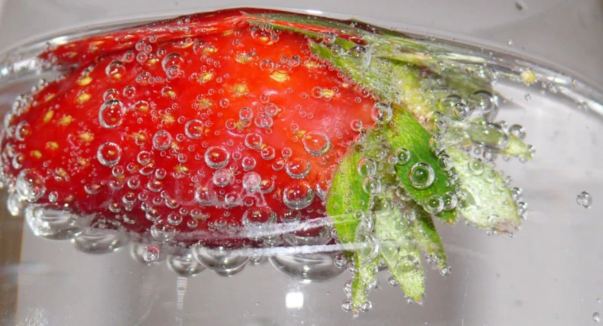 a strawberries and leaves in water with bubbles