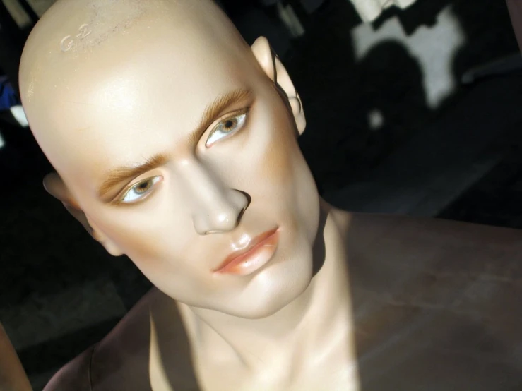 the mannequin's head is next to his face, with shadow on it