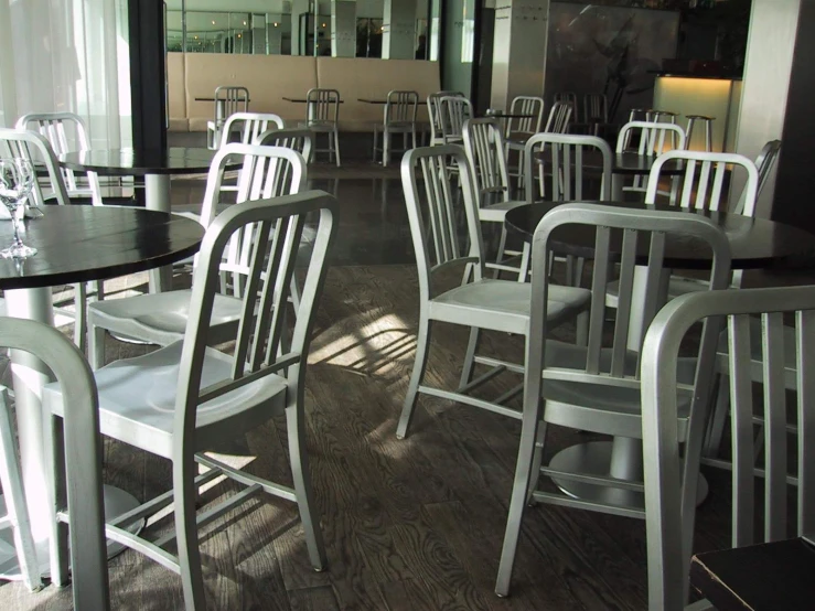 a restaurant with large windows and rows of white chairs