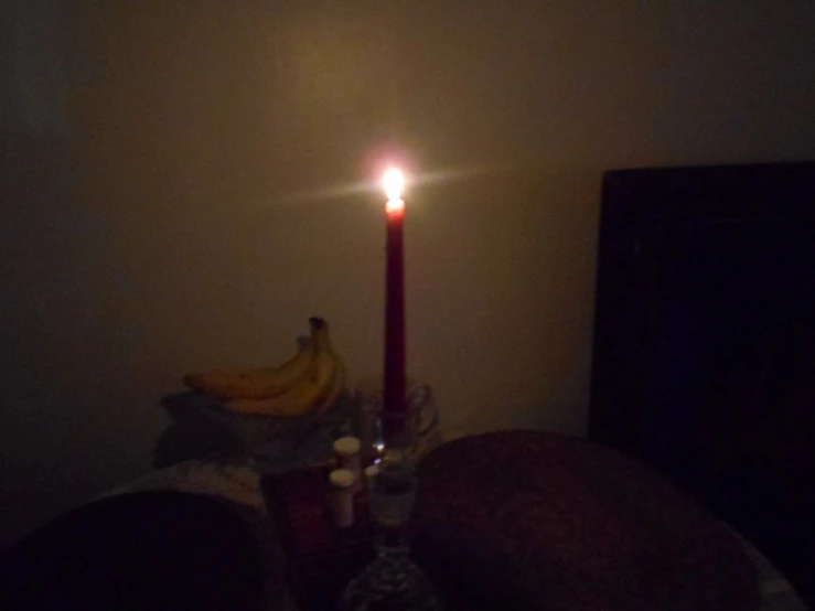 a candle and three candles are lit in the dark