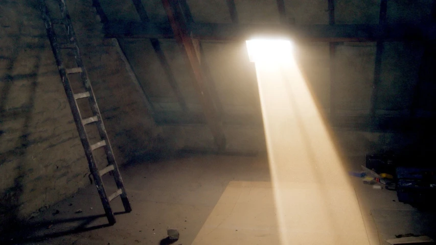 a ladder with a bright beam coming out of it in the middle of a dark room