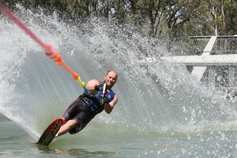 the man is water skiing while being pulled on his board