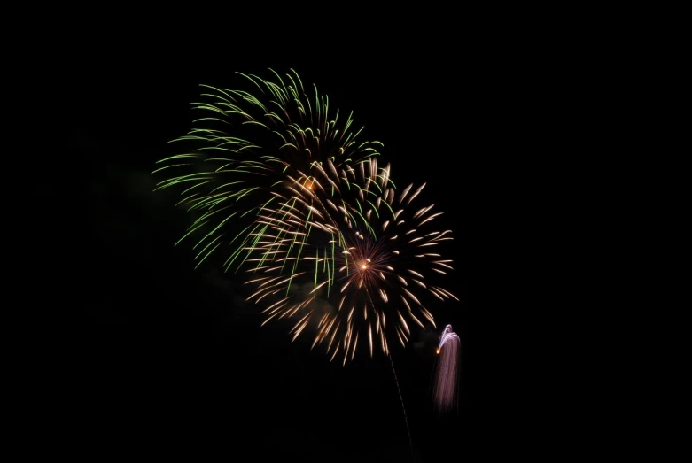 a black night with a green and red fireworks