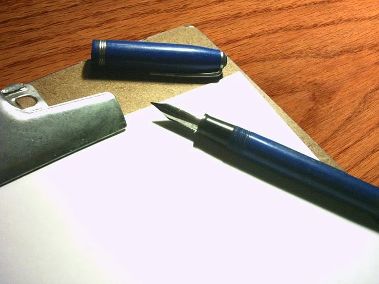 a pen and paper sit on top of a clipboard