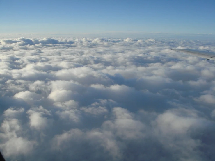 looking out an airplane window at white clouds below