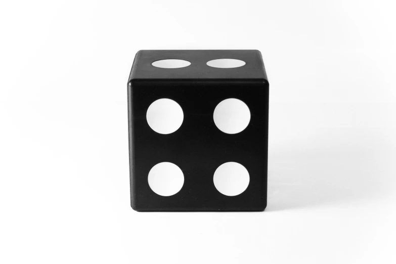 a black and white dice with four white dots