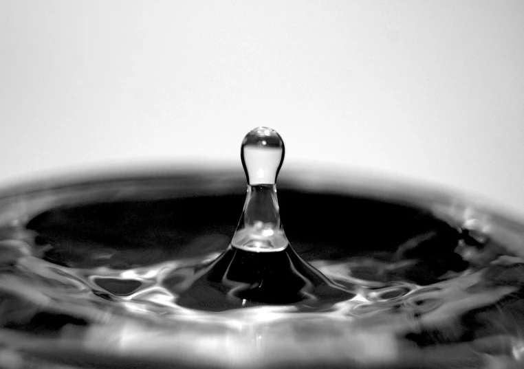 a drop of water sitting in the middle of a glass container