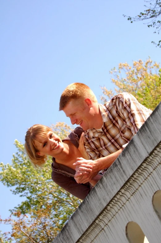 man and woman sitting on top of a stone structure