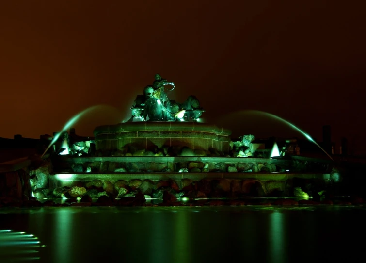 the fountain is lit up in green and red