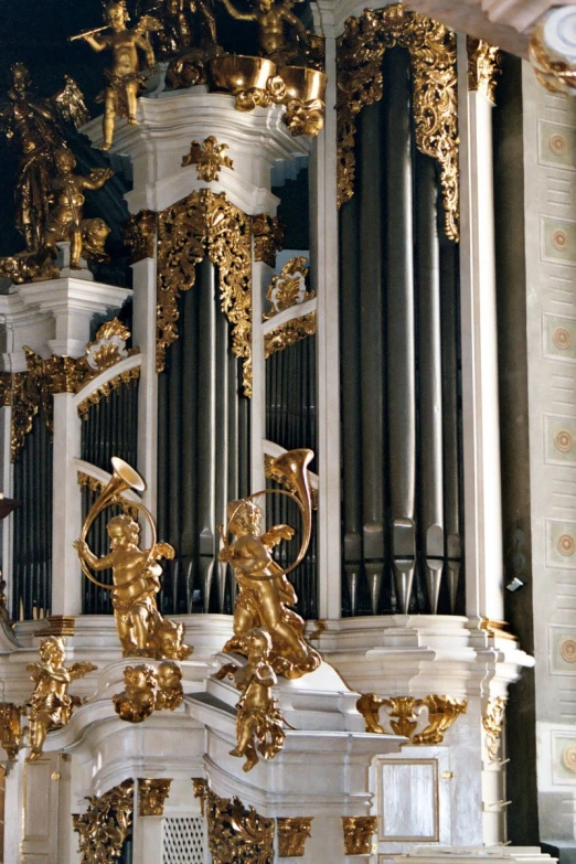 the pipe organ of an old cathedral has ornately carved gold