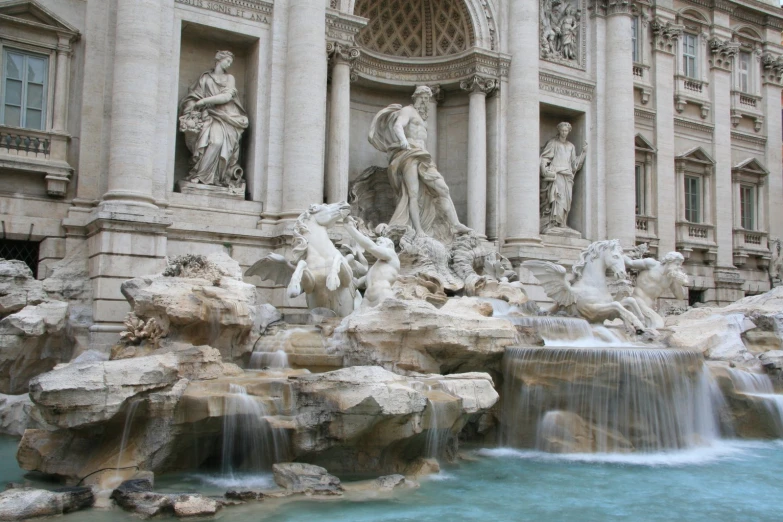 an elaborate fountain and the statues are sitting on rocks