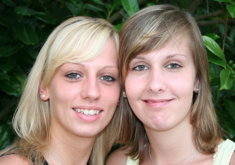 two woman standing next to each other smiling