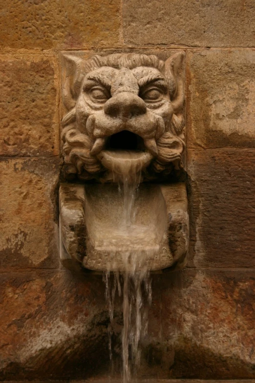a water fountain with a stone animal sculpture