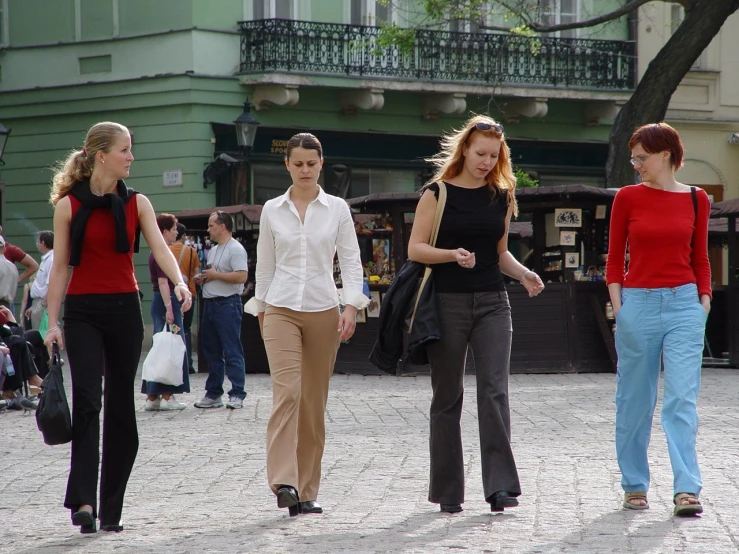 three women walk through the town square