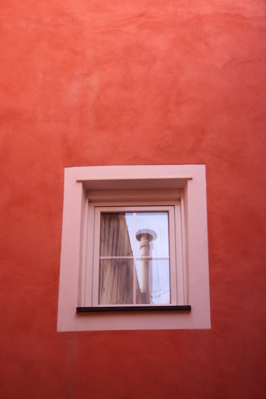 a window and light pole against an orange wall