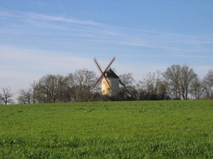 an old windmill in a field on a clear day