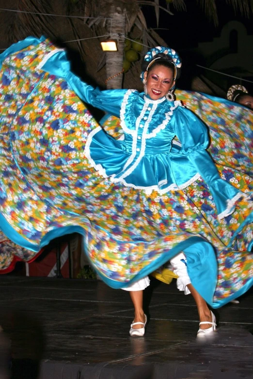 a female wearing a multicolored dress is performing on stage