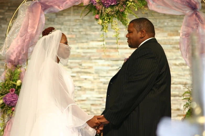 the bride and groom are holding hands at their wedding