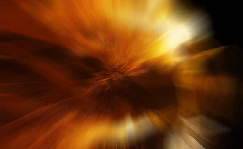 an orange flower blurry in the dark
