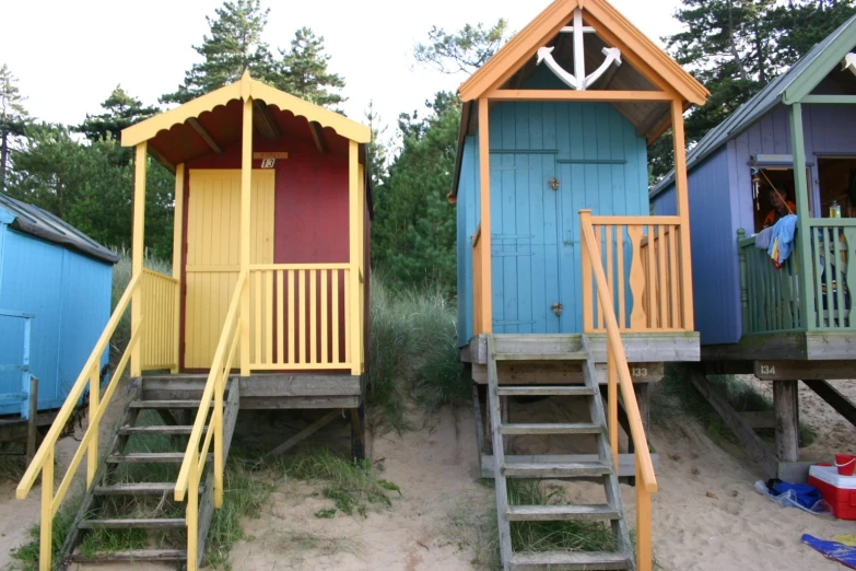 several beach huts with stairs to the rooms