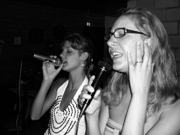 black and white pograph of two women at microphones