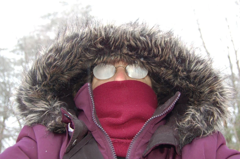 the woman is wearing a winter coat and looking up